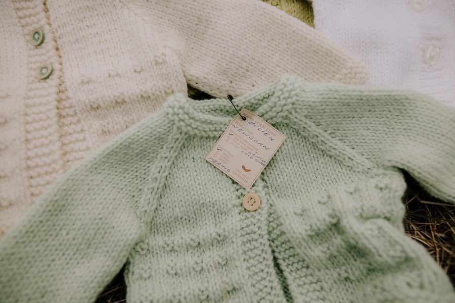 Hand-knitted baby cardigans with Nest Collective tags