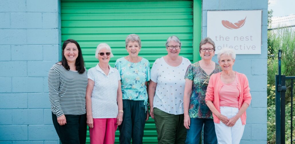 The Nest Collective volunteers standing together outside the hub